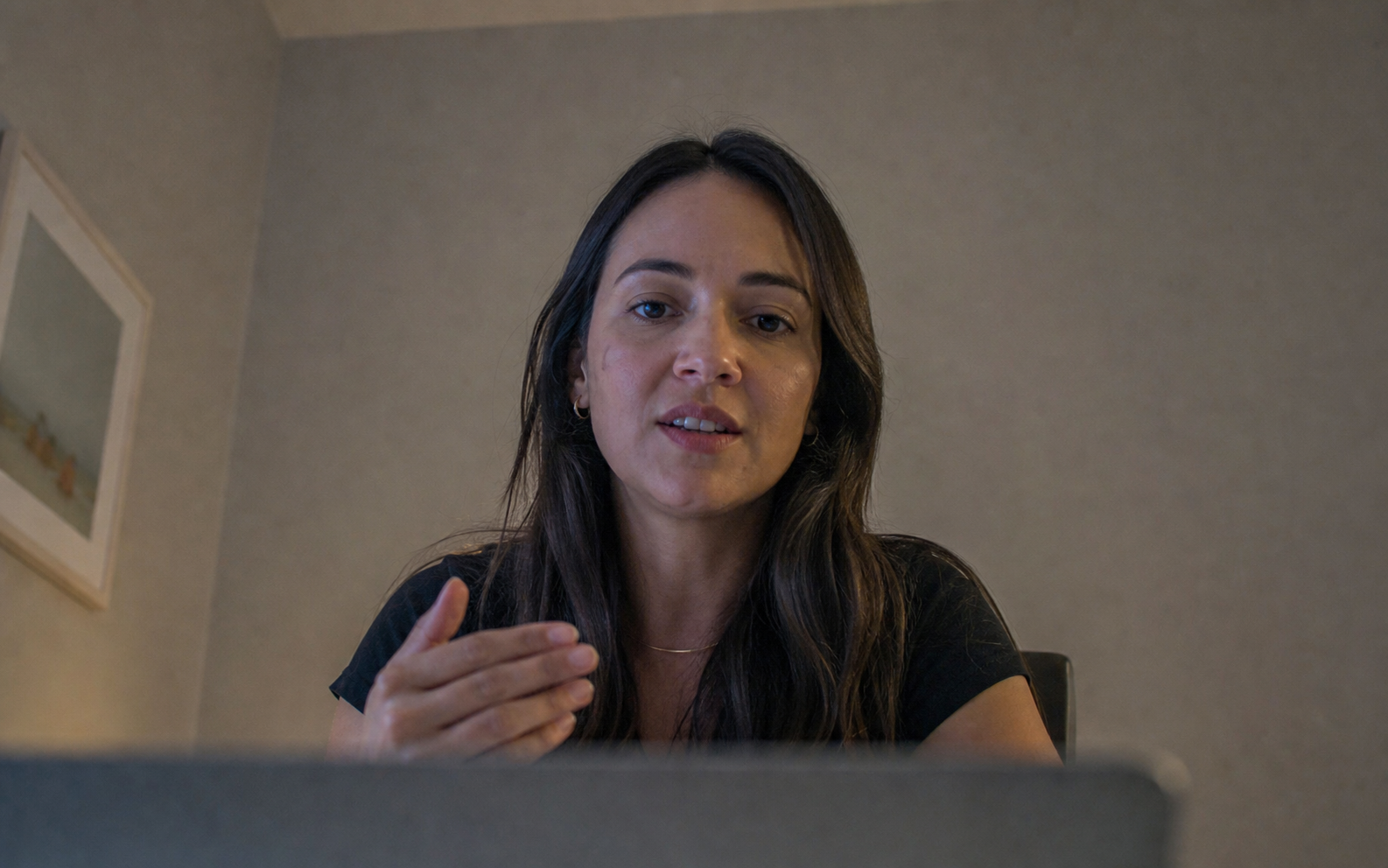 Pessoa em chamada de vídeo com luz fraca, ângulo baixo e aparência improvisada